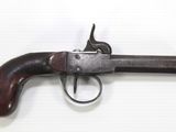 a close up of a gun with a wooden handle on a white surface