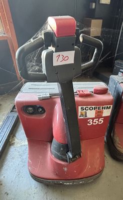 un chariot élévateur rouge et noir garé dans un entrepôt