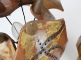 a close up of a sculpture of a bird on a wire