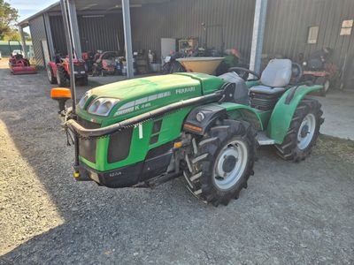 un tracteur vert garé devant un bâtiment