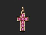 un pendentif en forme de croix en or orné de pierres roses sur fond noir
