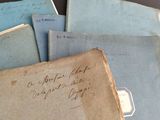 several old papers are stacked on top of each other on a table