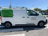 a white van parked in a parking lot with a green sign on the side of it