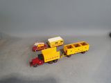 a toy train with a yellow trailer and a red truck