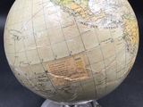 a small globe that is on a stand on a table