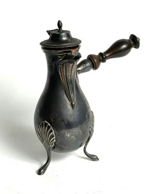 a small metal teapot with a wooden handle on a white surface