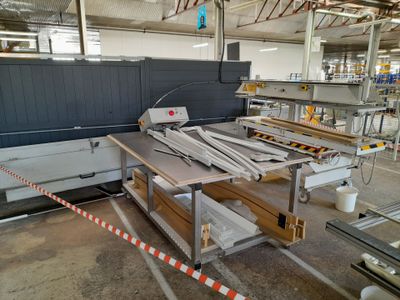 a machine that is cutting wood in a factory