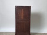 a tall wooden cabinet in the middle of a carpeted room