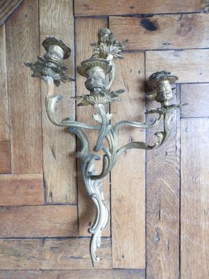 a wall sconce that has a bunch of flowers on it