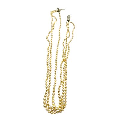 a gold necklace with three strands of pearls on a white background