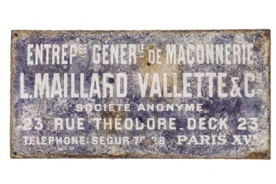 an old blue and white sign on the side of a building