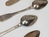 five spoons and two spoons sitting on a table