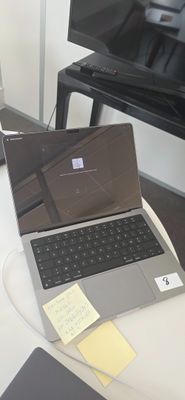 un ordinateur portable posé sur une table devant un téléviseur