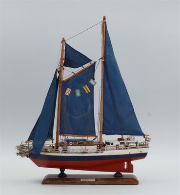 une petite maquette de voilier aux voiles bleues