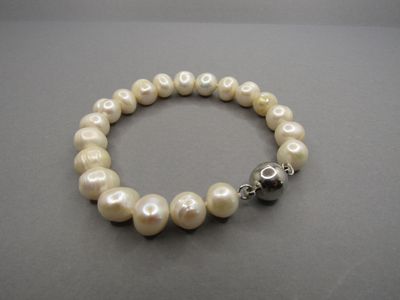 a close up of a bracelet with pearls on a table