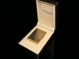 une boîte contenant un briquet, posée sur une surface noire