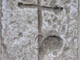 une croix sculptée dans un bloc de pierre sur le mur d'un bâtiment