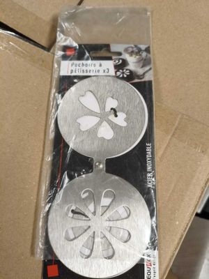 deux boutons métalliques dans un emballage placé dans une boîte en carton