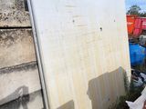 a white refrigerator sitting on the ground next to a pile of trash