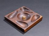 a wooden plate with a bowl and spoons on it