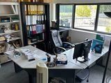 a desk with a fan in the corner of the room