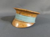 a small wooden bowl on a table with a blue ribbon around it