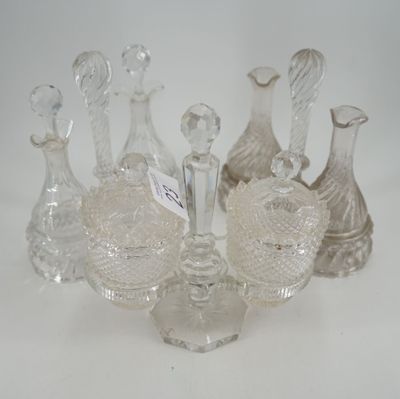 Plusieurs vases en verre transparent sont alignés sur une surface blanche