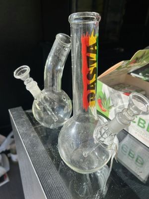 Deux pipes à eau en verre transparent. On y joint un vaporis…