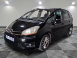 La petite voiture noire est garée dans le garage, sur le sol à damier.