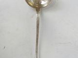 une cuillère en argent avec un manche de cuillère sur une table