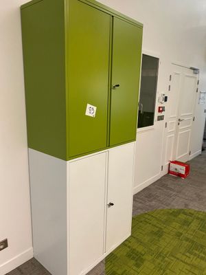 a green and white cabinet in a room with a green rug