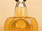 a bottle of perfume with a brown cap on it