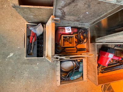 de nombreux outils qui se trouvent dans une boîte posée par terre