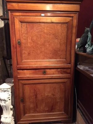 a tall wooden cabinet with a clock on top of it