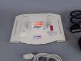 a nintendo game console and a charger sitting on a table