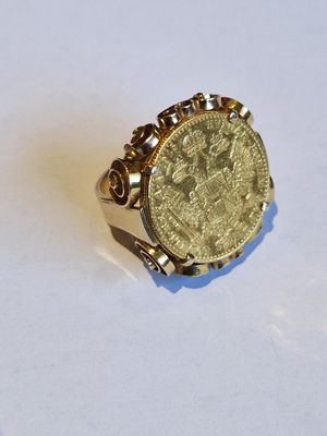 une image représentant une bague sur laquelle repose une pièce d'or