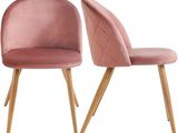 a pair of pink velvet chairs with wooden legs