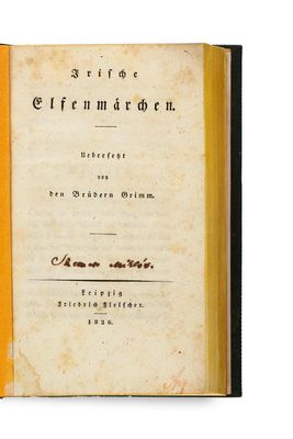 an old book with a yellow cover sitting on top of a white surface