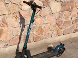 a scooter that is parked in front of a stone wall