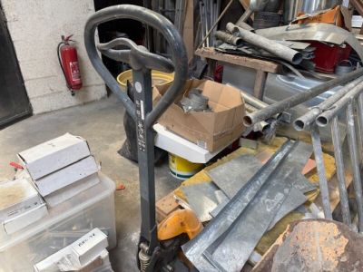 un tas de bric-à-brac dans un garage, avec une fourche et d'autres objets
