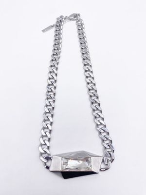 un collier en argent avec une pierre suspendue à une chaîne, sur fond blanc
