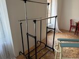a room with a chair, a table, and a rack in it