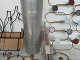 a metal vase sitting on top of a table next to a bunch of wire