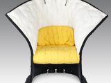 une chaise noire et blanche sur laquelle est posé un coussin jaune