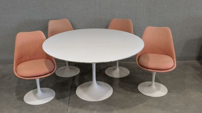 an image of a white table with four orange chairs around it