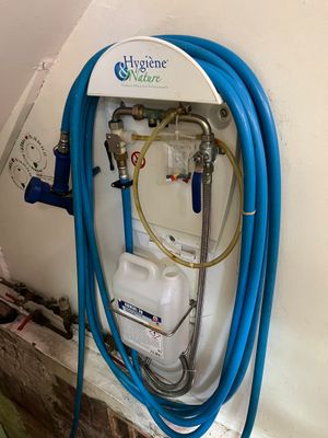 un tuyau bleu fixé au mur à côté d'un chauffe-eau