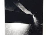 a black and white photo of a knife cutting a piece of paper