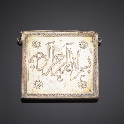 an old silver plaque with arabic writing on it on a black background