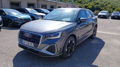 L'Audi QX est garée sur un parking, à côté d'autres voitures.