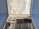 silverware in a silver case on a blue surface